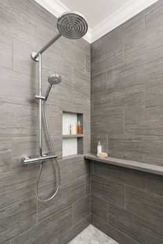 the shower head is mounted to the side of the wall in this bathroom with gray tile