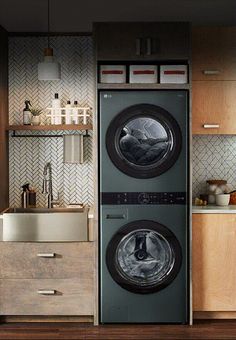 a washer and dryer in a kitchen with wooden cabinets on either side of the washer