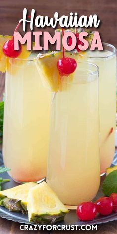 two glasses filled with pineapple mimosa sitting on top of a table