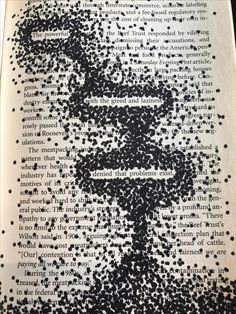 an open book with black and white ink sprinkles on it, in the shape of a man's face