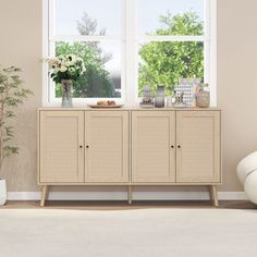 a living room scene with focus on the sideboard and large window in the background