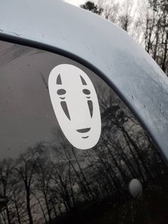 a sticker on the side of a car that has a face drawn on it