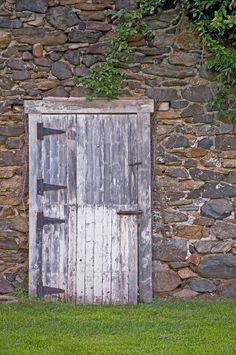 an old wooden door in front of a stone wall