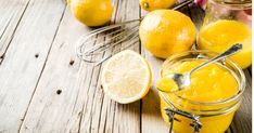 there are lemons and other fruit in the jars on the table with whisks