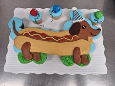 a birthday cake made to look like a hot dog and cupcakes