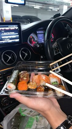 sushi in a plastic container with chopsticks sticking out of it