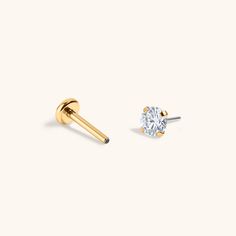 a pair of gold earrings with a single diamond