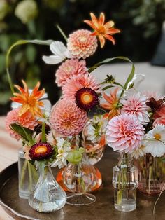 several vases with flowers in them sitting on a table