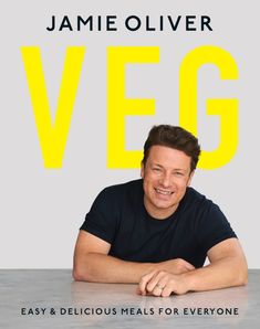 a man sitting at a table in front of a sign that says, veg easy and delicious meals for everyone