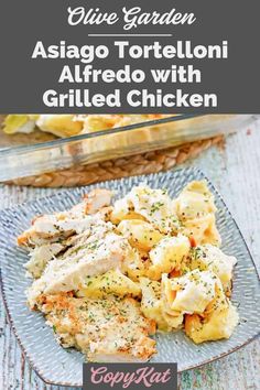 a plate filled with pasta and chicken on top of a wooden table