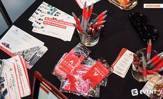 the table is covered with red pens and business cards