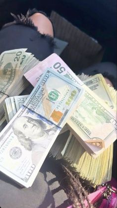 a pile of money sitting in the back seat of a car next to a woman