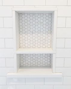 two white shelves with hexagonal tiles on them