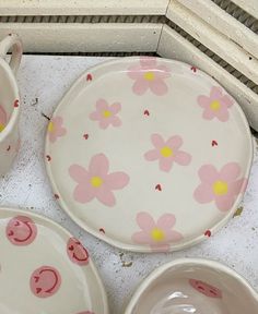 pink and yellow flowered dishes are sitting on the floor