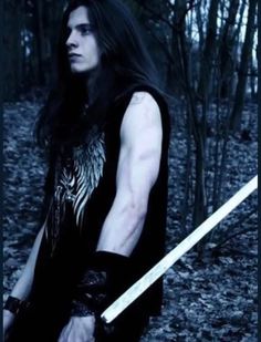 a man with long hair holding two swords in his hands while standing in the woods