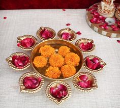 a bowl filled with flowers sitting on top of a white tablecloth next to other plates