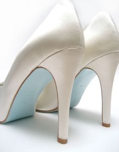 a pair of white high heeled shoes on top of each other