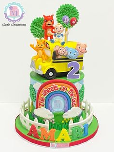 a birthday cake decorated with animals and cars