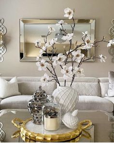 the living room is decorated with white flowers and silver accents, along with a gold coffee table