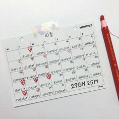 a calendar with hearts on it next to a pencil