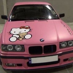 a pink car with a hello kitty sticker on the hood