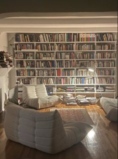 a living room filled with lots of furniture and bookshelves covered in bookcases