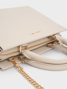 This product is made with at least 20% sustainable materials by weight. CHARLES & KEITH uses recycled, degradable, organic, and water-based materials in our eco-conscious collection. You can never go wrong with a classy carrier in a versatile shade, and this iteration of the Mirabelle bag is exactly that. The creamy ivory finish and structured silhouette makes clean lines the focal point, with a luxurious gold-accent bag charm to add shine. Maximising functionality, the roomy interior comes with inner compartments to keep all your essentials organised and secure. Carry this nifty bag with ease by its top handles, or attach the accompanying strap to turn it into a posh shoulder bag. Structured Top, Charles Keith, Cute Bags, Handle Bag, Gold Accents, Top Handle, Top Handle Bag, Handles, Shoulder Bag