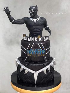 a cake made to look like the black panther is on top of a stand with its hands in the air