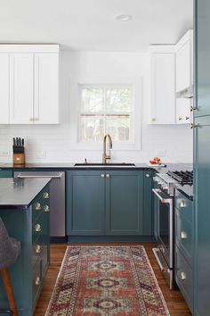 a kitchen with blue cabinets and an area rug