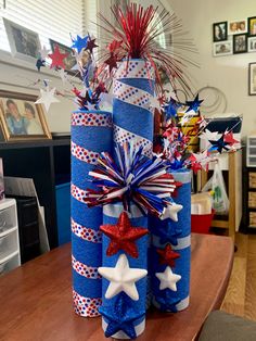 two wrapped presents are sitting on a table with red, white and blue decorations in them