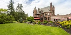 a large house with many trees and bushes around it