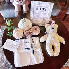 a teddy bear sitting on top of a table next to a baby's diaper