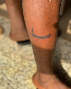 a man with a tattoo on his leg that has a small boat on the water