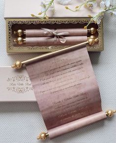 the wedding stationery is set up in a box with gold trimmings and pearls