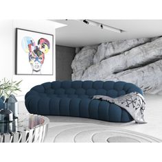 a living room filled with furniture and a large rock wall behind the couch is an art piece