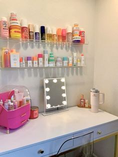 a white desk topped with a mirror and lots of bottles