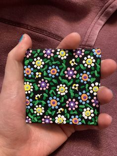 a person is holding a small case with flowers on it