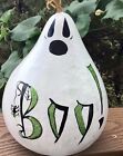 a painted rock with the word boo on it sitting in front of some plants and bushes