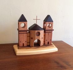 a wooden model of a church with a cross on the top and two towers above it