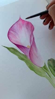 a person is drawing a flower with watercolors