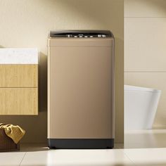 a beige washer sitting on top of a white tiled floor next to a toilet