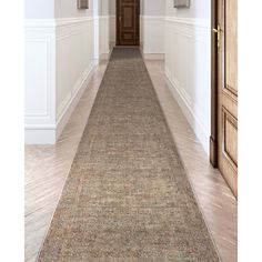 a long hallway with white walls and wooden doors