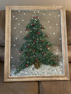 a small christmas tree in a glass frame