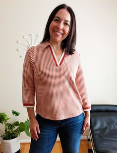 a woman is standing in front of a chair and smiling at the camera with her hands on her hips