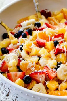 a bowl filled with fruit and cheese on top of a table