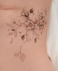 a woman's stomach with flowers and leaves on it