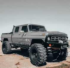 a gray truck parked on top of a sandy beach