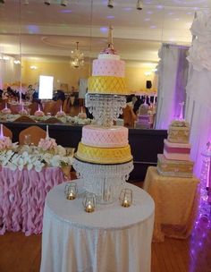 a wedding cake sitting on top of a table in front of other tables and chairs