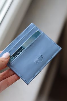 a person is holding a blue card case