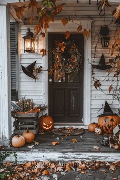 a front porch decorated for halloween with pumpkins and other decorations